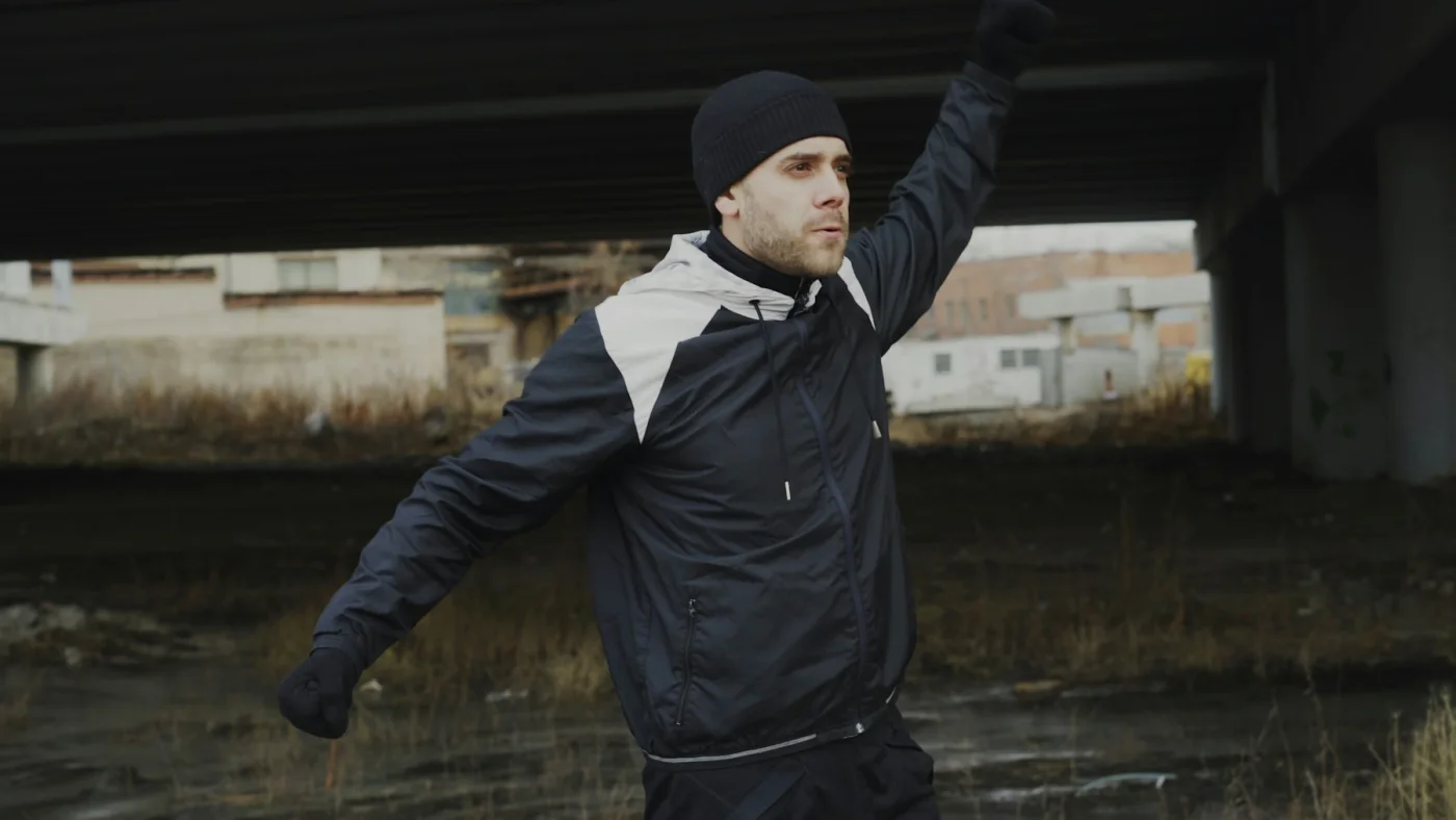 Person in Sportkleidung beim Aufwärmen unter einer Brücke