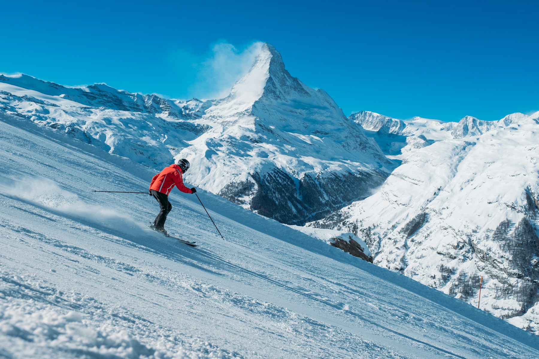 Skifahrer bei einer Kurve auf einer verschneiten Piste